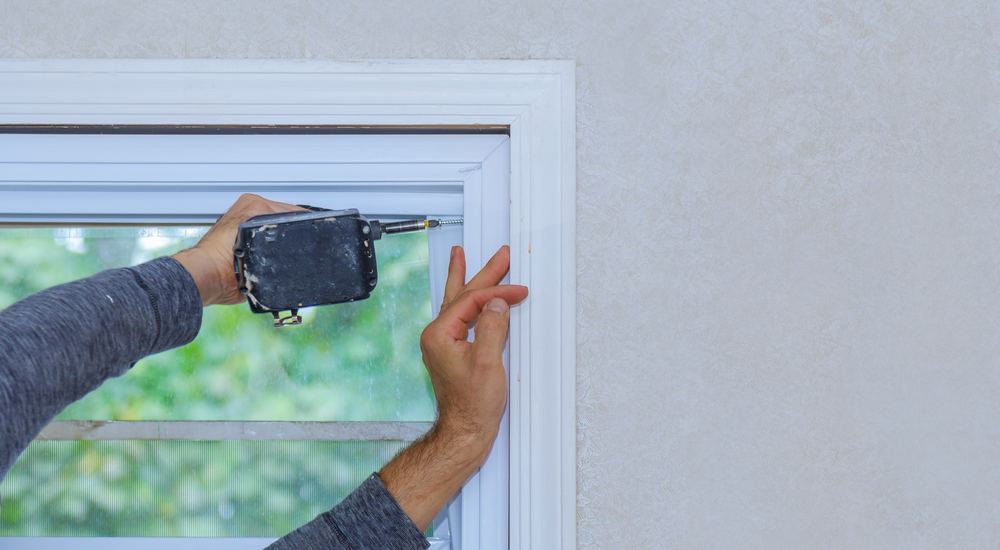 Stock photo of a contractor installing a window used in an illustrative fictional ad example